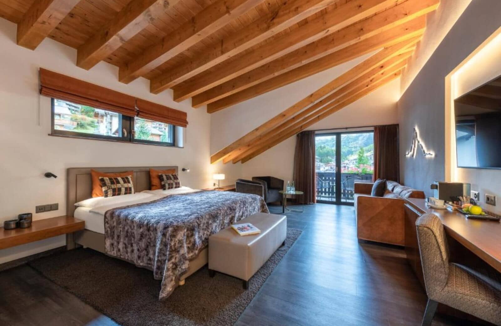 Bedroom with king bed, vaulted timber ceilings, and mountain-view balcony