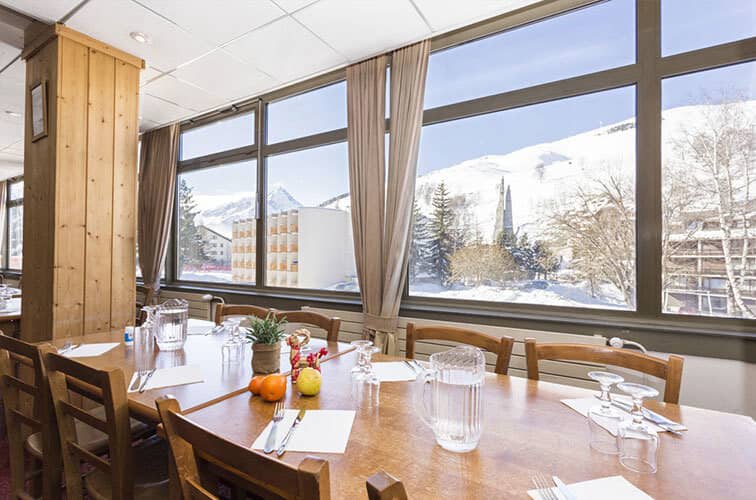Dining area with large windows overlooking snow-covered mountains