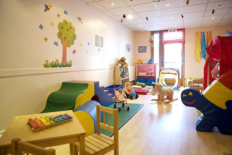 Children's playroom featuring soft play foam blocks, toys, and wood flooring