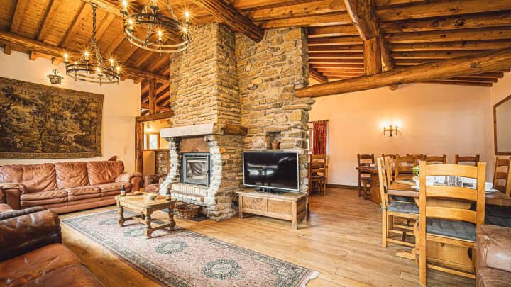 Open-plan living area with stone fireplace and dining seating for 10