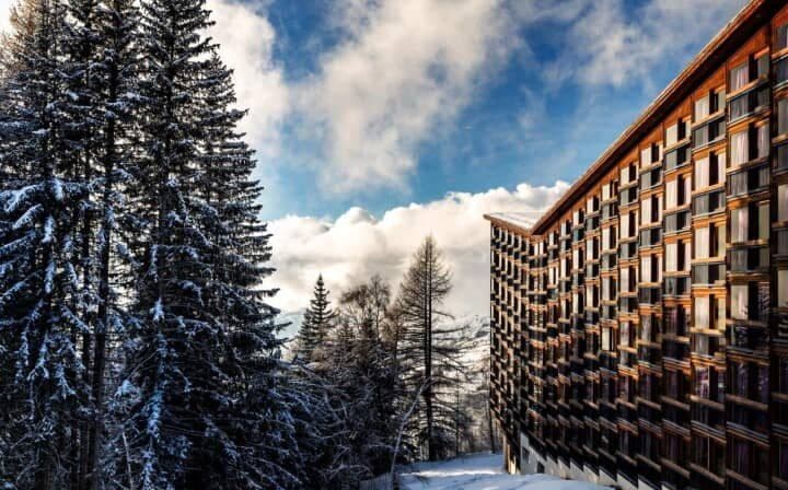 Ski-in/ski-out chalet exterior with floor-to-ceiling windows and forest view
