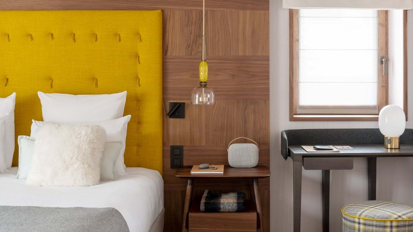 Guest bedroom featuring integrated bedside lighting and dedicated workspace with desk