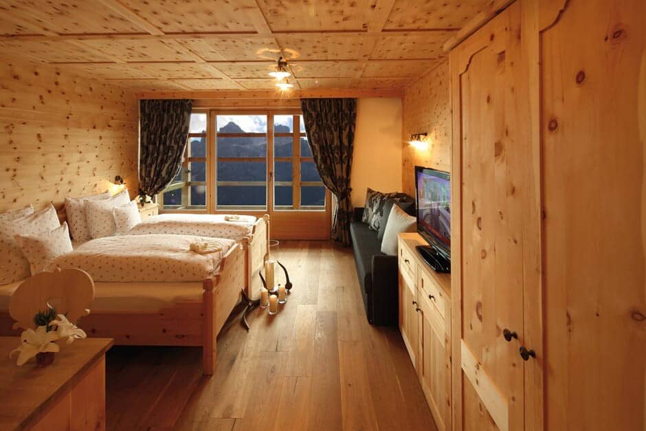 Wood-paneled bedroom with twin beds and mountain views
