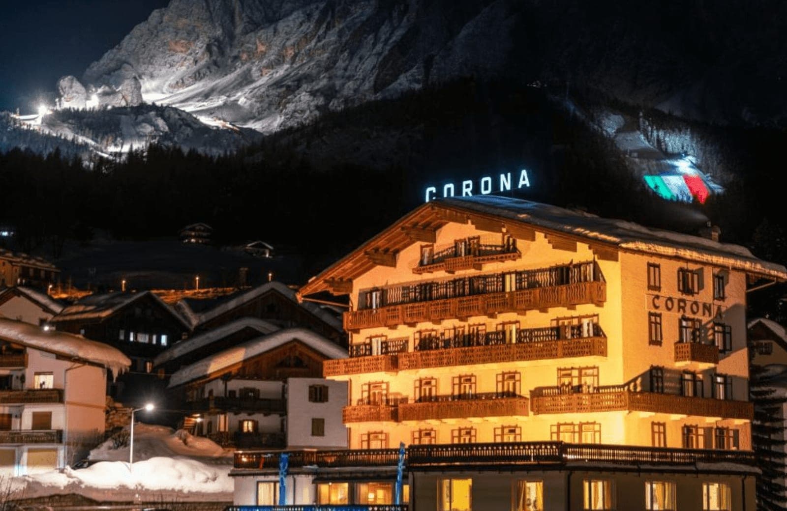 Chalet exterior at night with private balconies and illuminated mountain backdrop