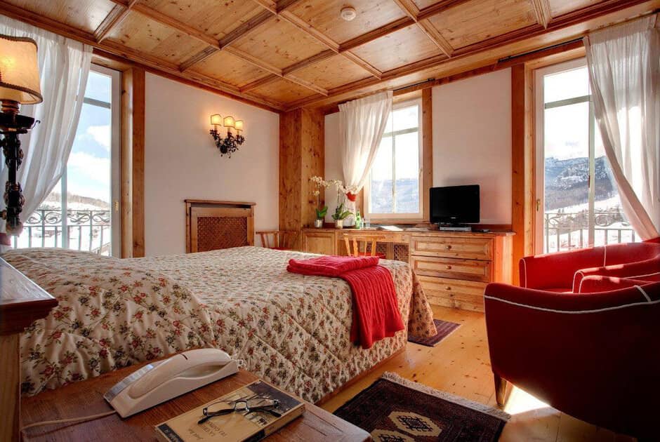 Bedroom with queen bed, wood-coffered ceiling, and mountain views
