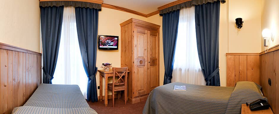 Guest bedroom with two twin beds, workspace, and pine wood paneling