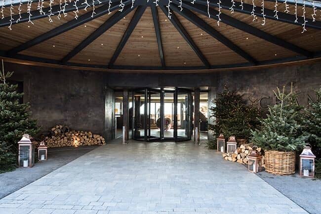Porte-cochère entrance with revolving glass doors and firewood storage
