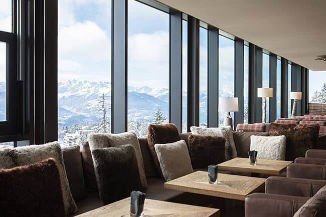 Lounge area with panoramic mountain views and floor-to-ceiling windows