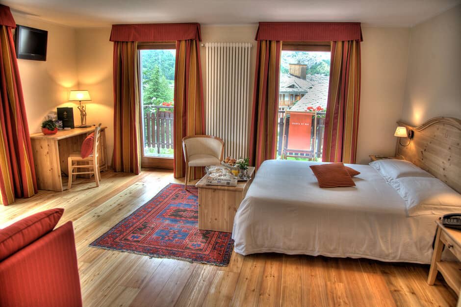 Guest bedroom with king bed, work desk, and balcony access