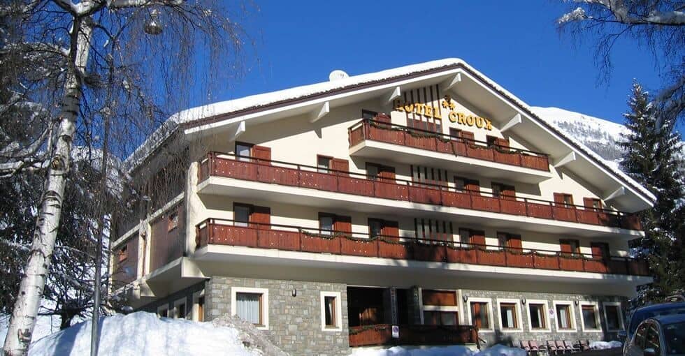 Alpine exterior with private room balconies and mountain backdrop