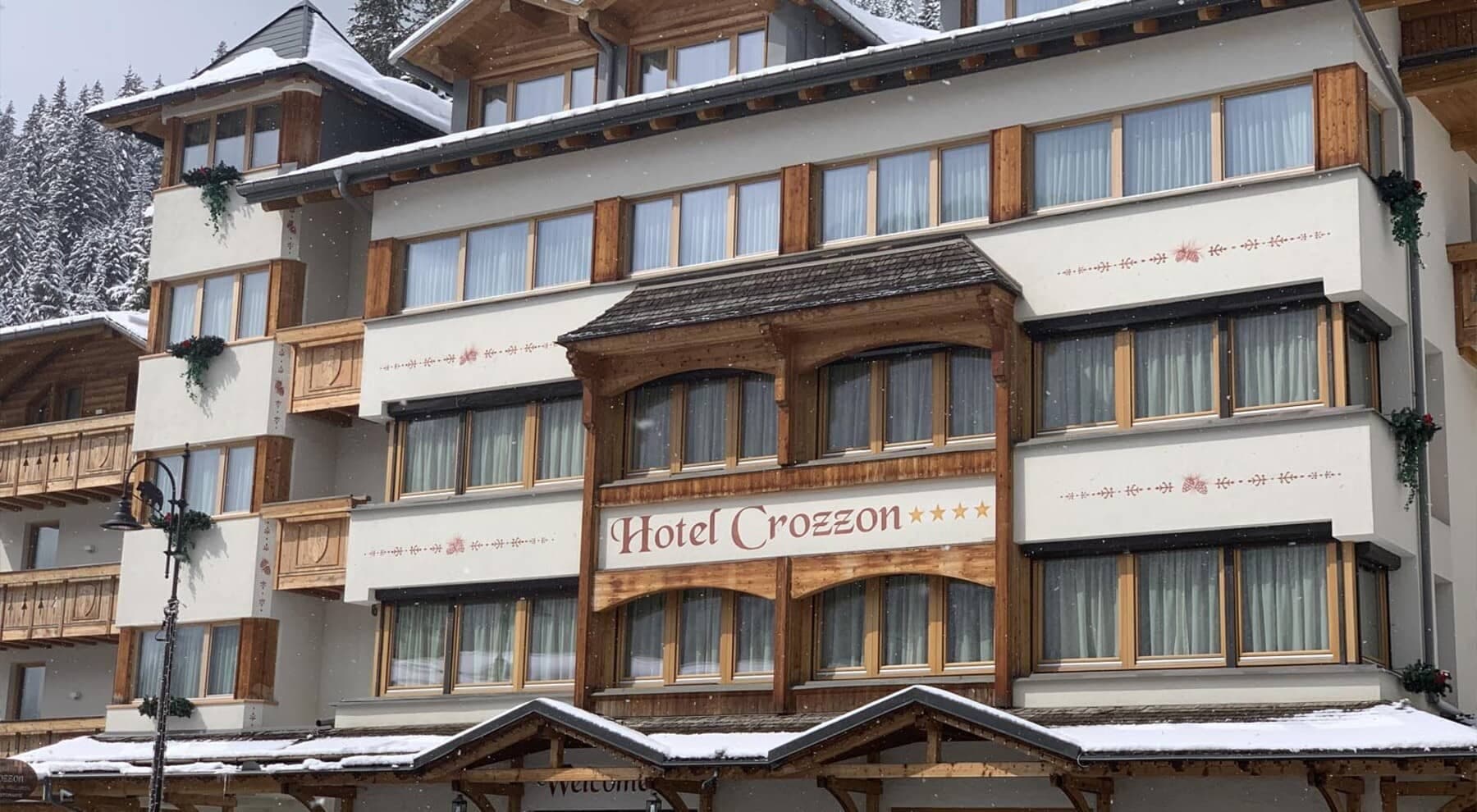 Hotel exterior with traditional alpine woodwork and private balconies