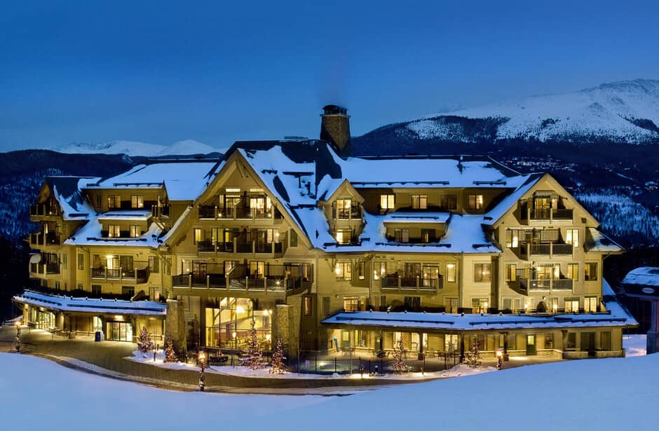 Mountain lodge exterior with private balconies and snow-capped peak views