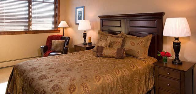 Guest bedroom with queen bed and leather armchair reading area