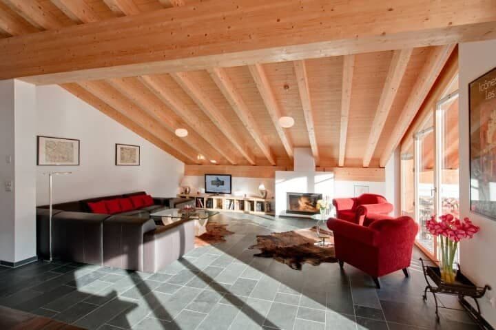Living area with wood-beam ceilings, wood-burning fireplace, and slate tile floors
