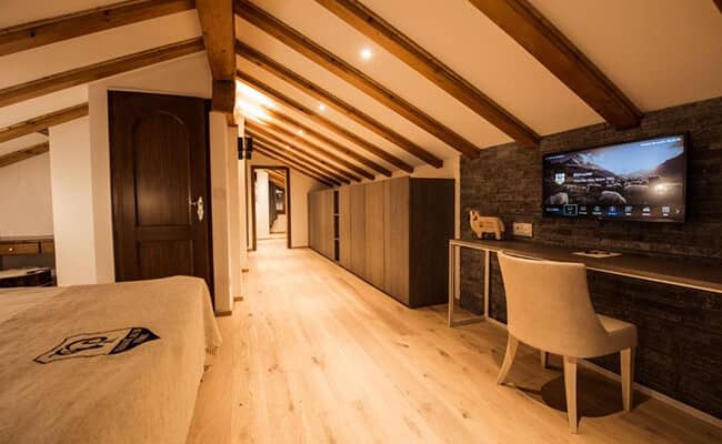 Attic bedroom with desk workspace, Smart TV, and built-in storage cabinets