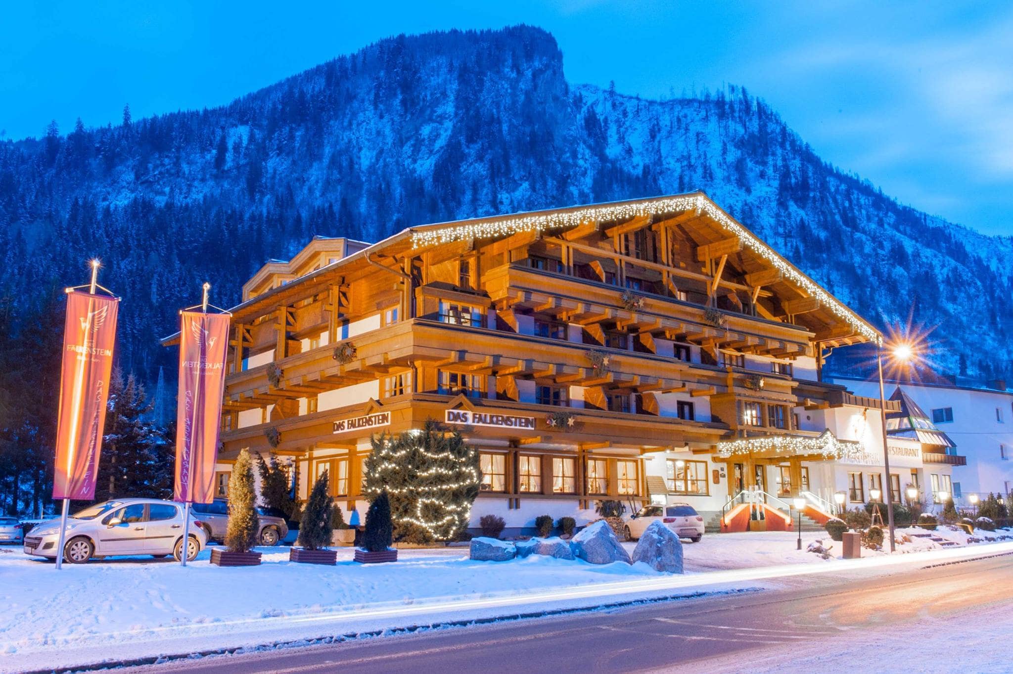 Chalet building with private balconies; mountain backdrop