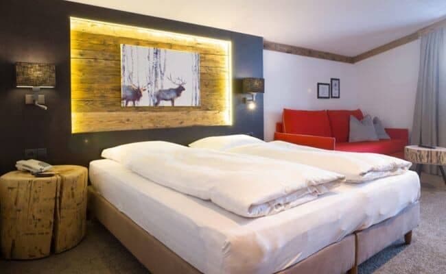 Bedroom with king bed and red sofa seating