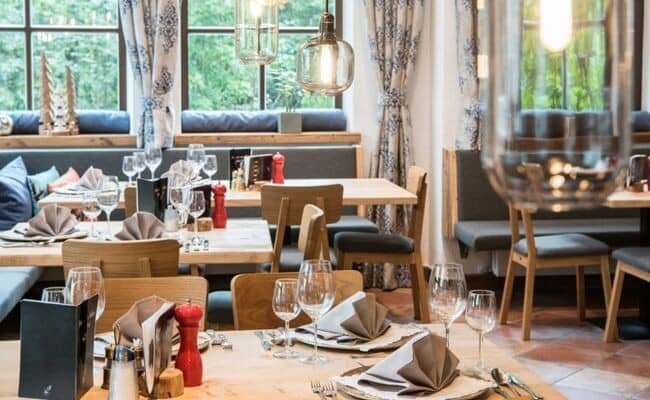 Dining area with banquet seating and garden views