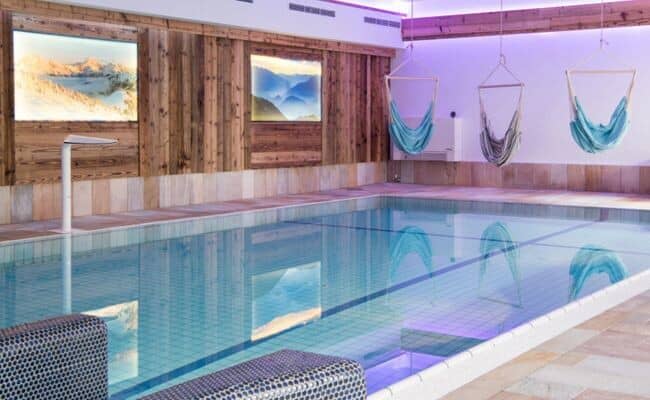 Indoor swimming pool with hanging hammock chairs