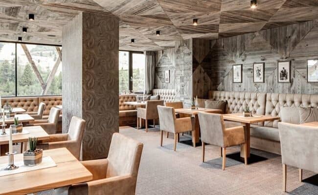 Dining area with tufted booth seating and reclaimed wood paneling