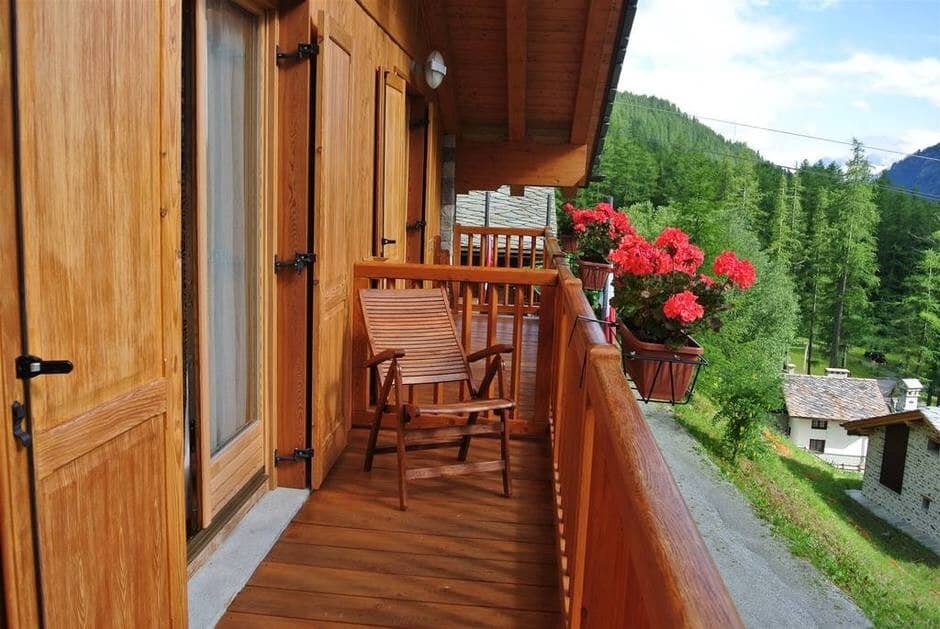 Private wooden balcony with forest views and folding lounge chair