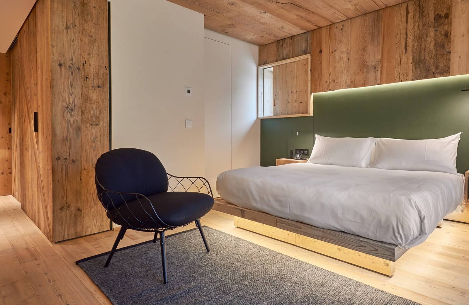 Bedroom with king bed and reclaimed wood paneling