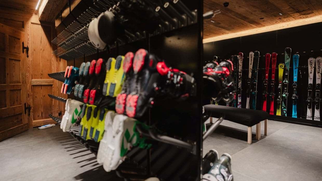 Ski storage room featuring heated boot racks and bench seating