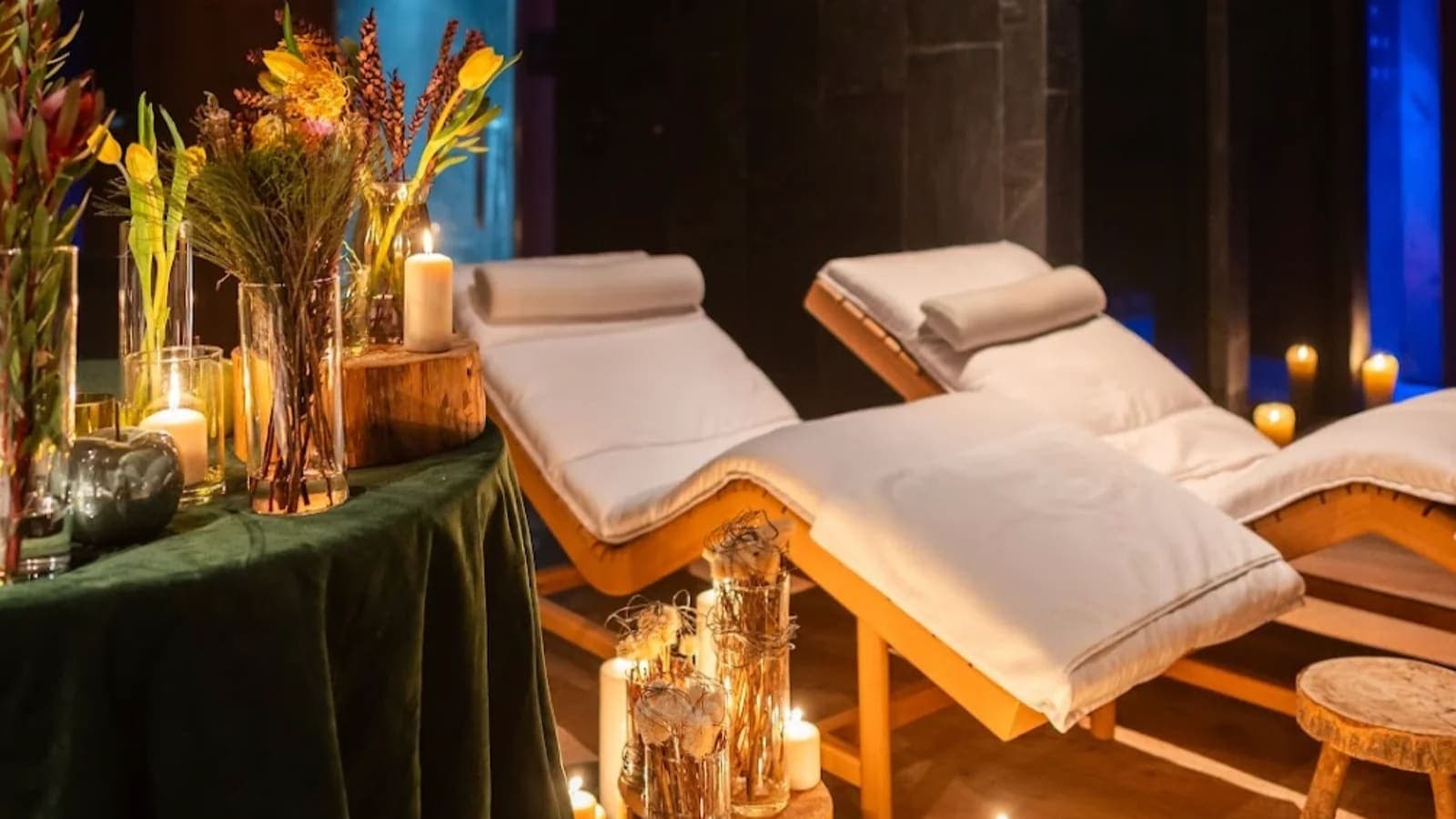Spa relaxation room with ergonomic wooden loungers and candle lighting