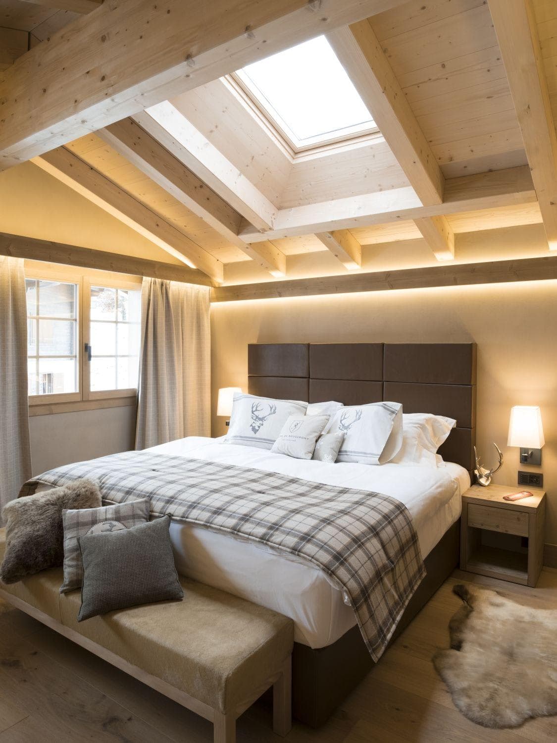Bedroom with king bed and skylight over exposed wood beams