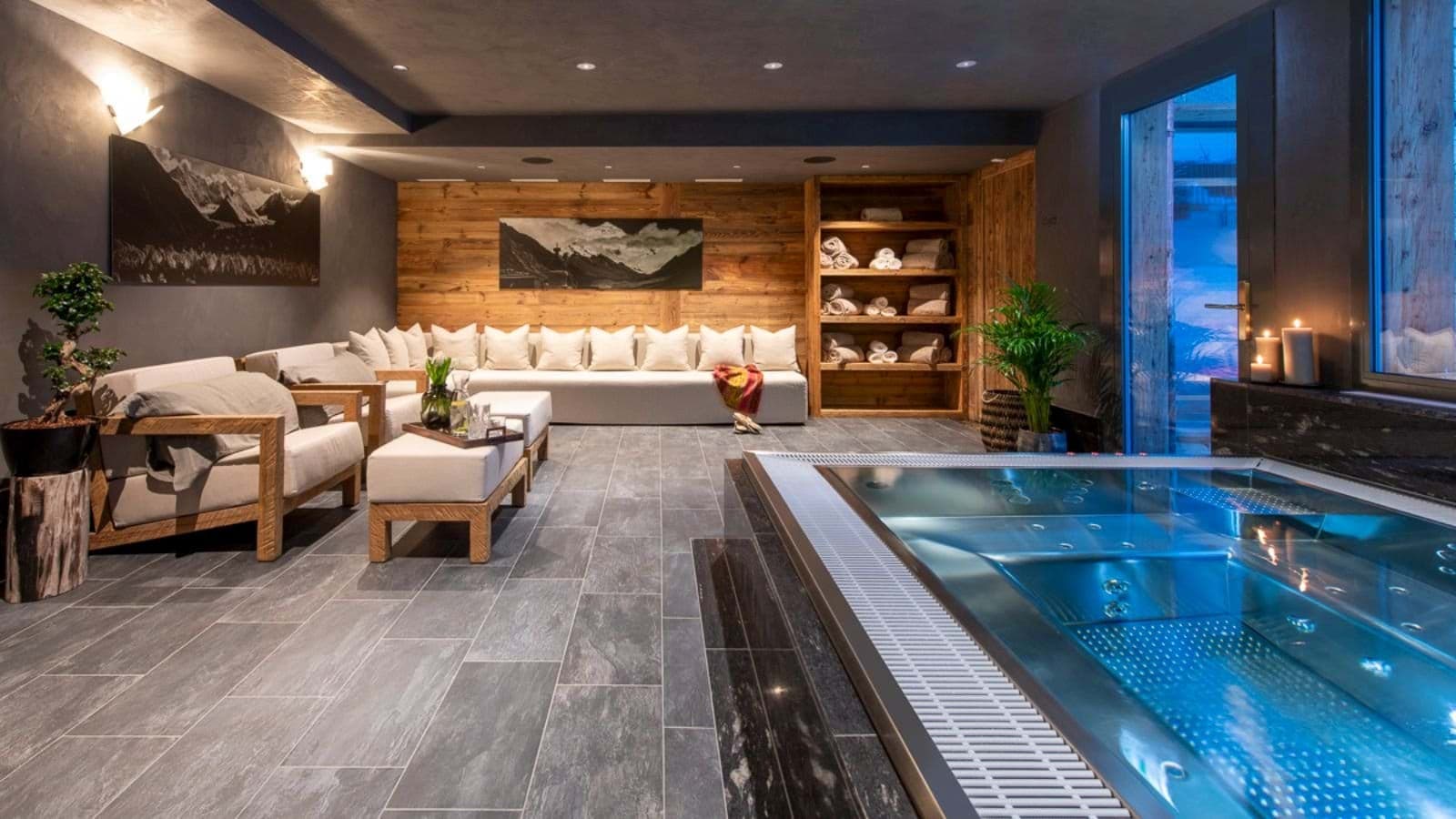 Indoor spa area with stainless steel hot tub and lounge seating