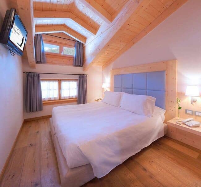 Loft bedroom with king bed and vaulted timber ceilings