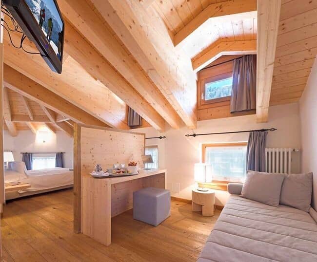 Loft bedroom with twin daybed and integrated desk; vaulted wood ceilings