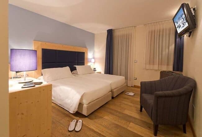 Guest bedroom with two twin beds and wall-mounted TV