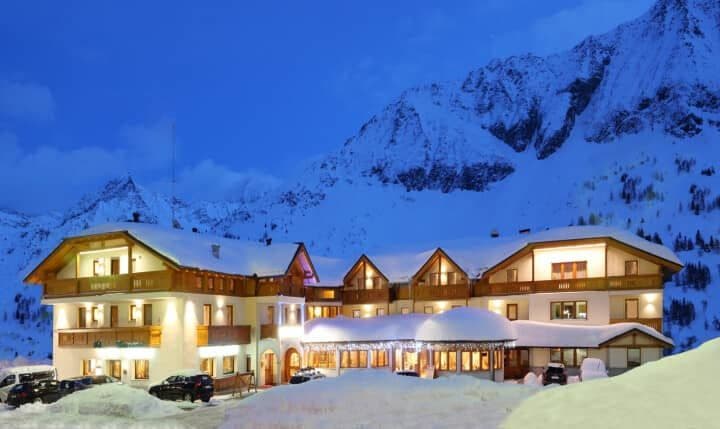 Ski-in/ski-out chalet exterior with mountain backdrop and on-site parking