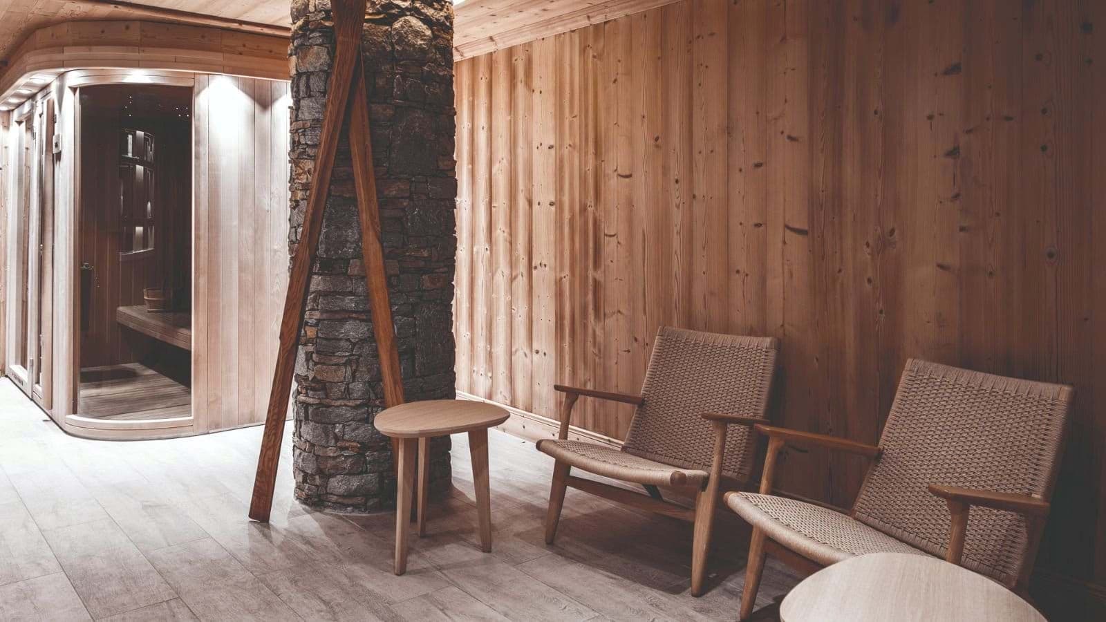 Private sauna with glass door and adjacent relaxation seating