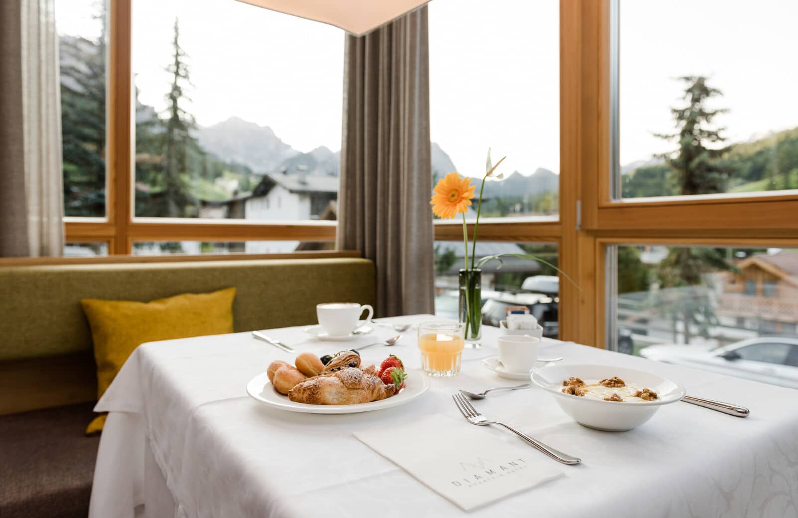 Dining nook with bench seating and floor-to-ceiling mountain views