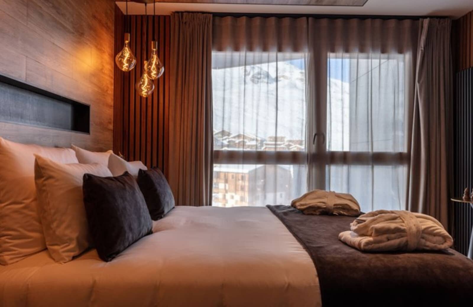 Bedroom with king bed and floor-to-ceiling snowy mountain views