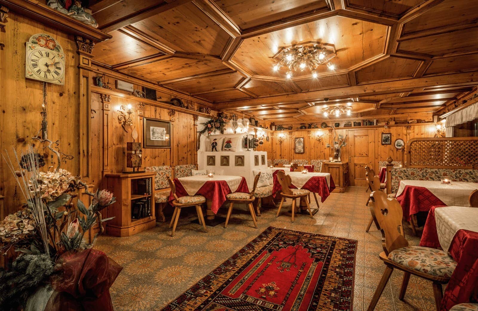 Dining area with wood-paneled walls and traditional masonry heater
