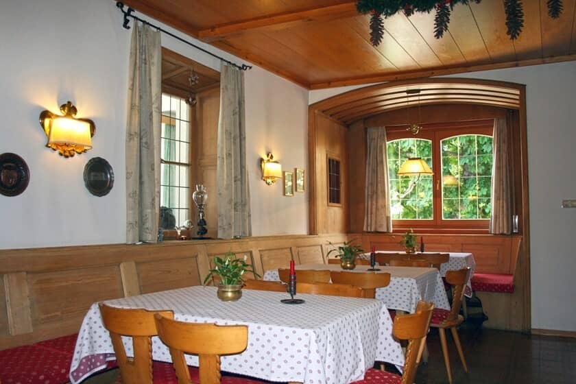 Dining area with traditional banquette seating and wood-paneled alcove