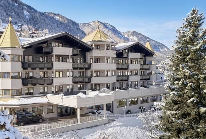 Ski-in/ski-out hotel exterior with private balconies and mountain backdrop