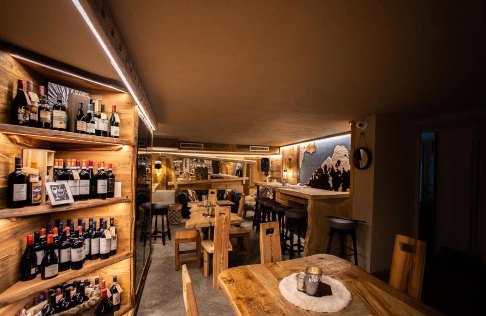 Alpine wine lounge with backlit shelving and mixed table seating