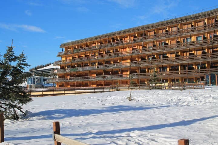 Ski-in/ski-out apartment building with private balconies and snow-covered grounds