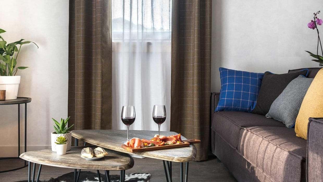 Living area with dark sofa and nested wooden coffee tables