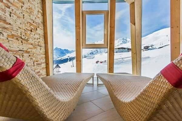 Relaxation area with wicker loungers and panoramic ski slope views