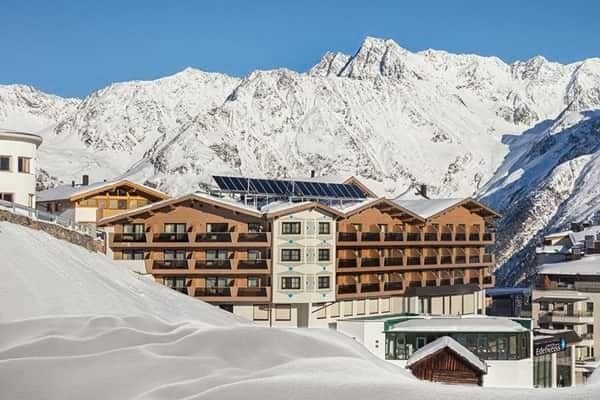 Alpine lodge exterior with private balconies and mountain views