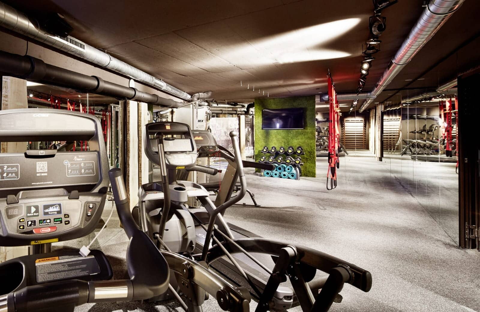 Fitness center with cardio machines, TRX trainers, and free weights