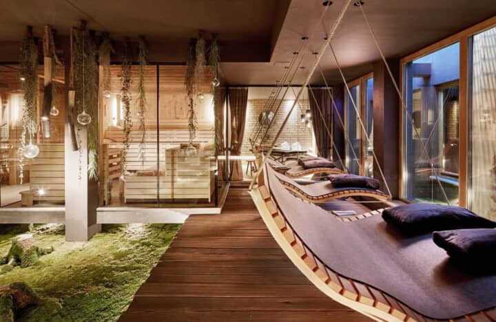 Spa lounge with suspended daybeds and glass-walled sauna access
