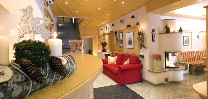 Lobby lounge with red sofa and wood-burning corner fireplace
