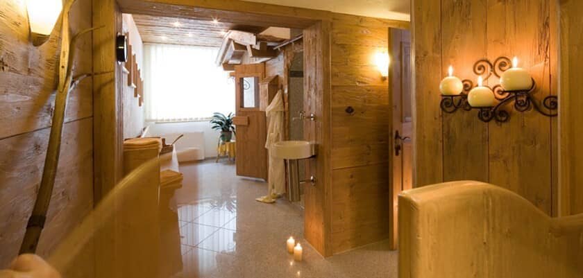 Wood-paneled bathroom featuring pedestal sink and separate soaking tub
