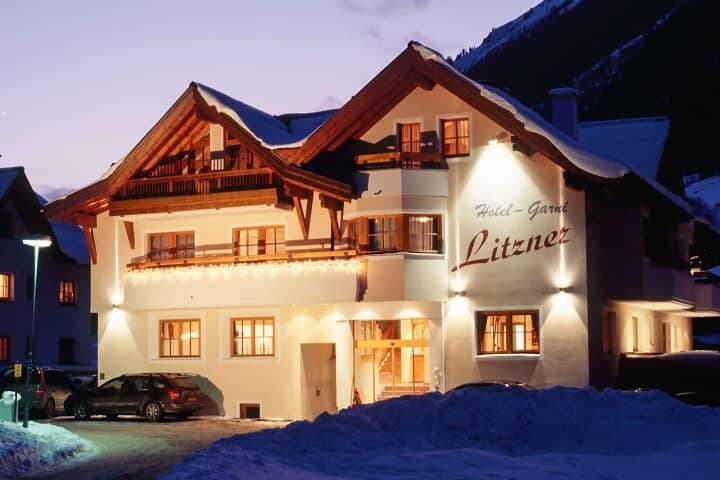 Chalet exterior at dusk with private balconies and on-site parking